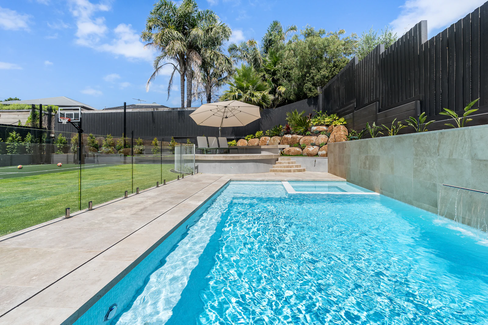 Outdoor swimming pool surrounded by a glass barrier